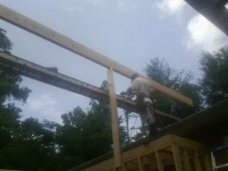 Carpenter setting a ridge beam over a new addition frame — Ice Dam Removal by Roofing Brothers in La Porte