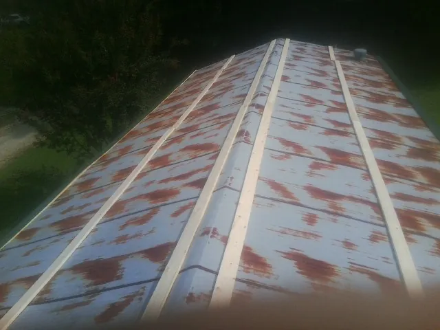 Rusted metal roof panels with new wood purlins before replacement — Storm Damage Roof Repair in La Porte by Roofing Brothers