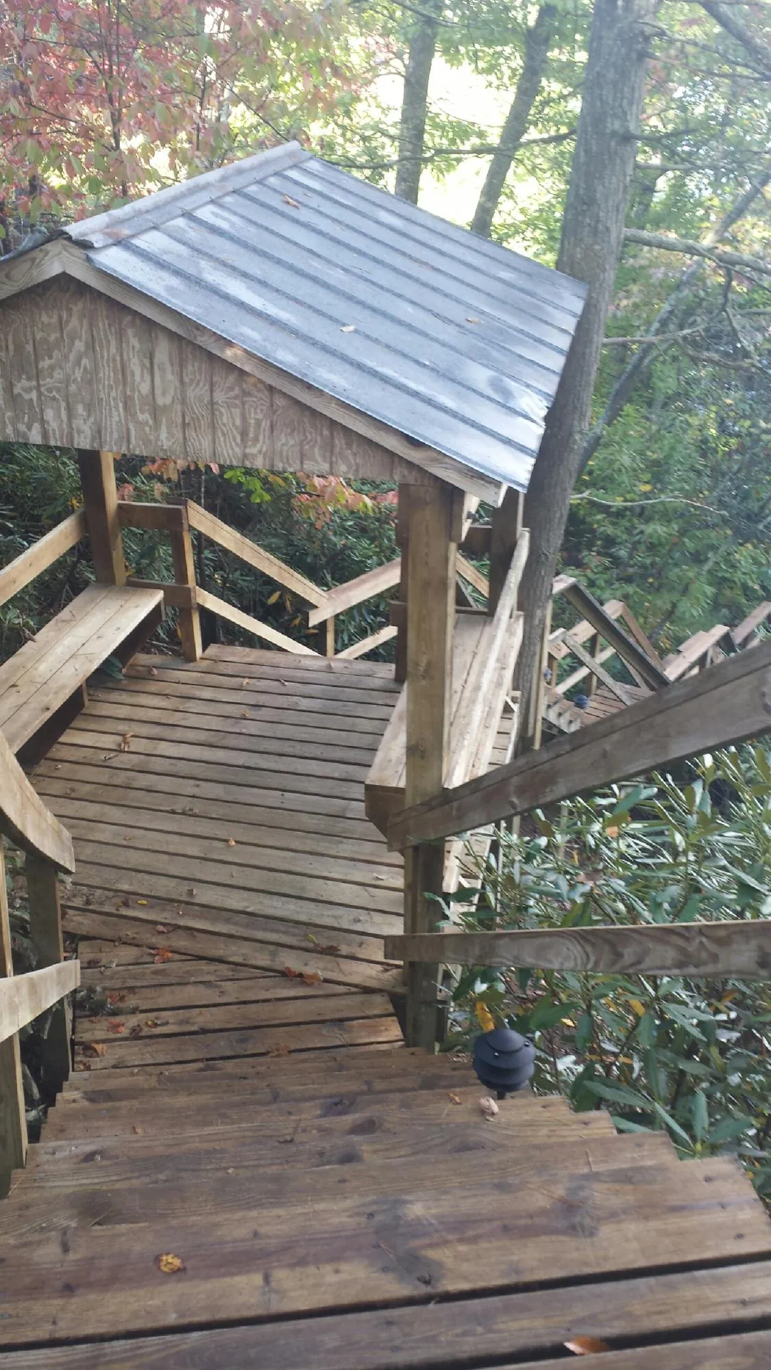 Metal roofed shelter over wooden steps on a wooded walkway — Skylight Repair & Installation work by our crew in La Porte